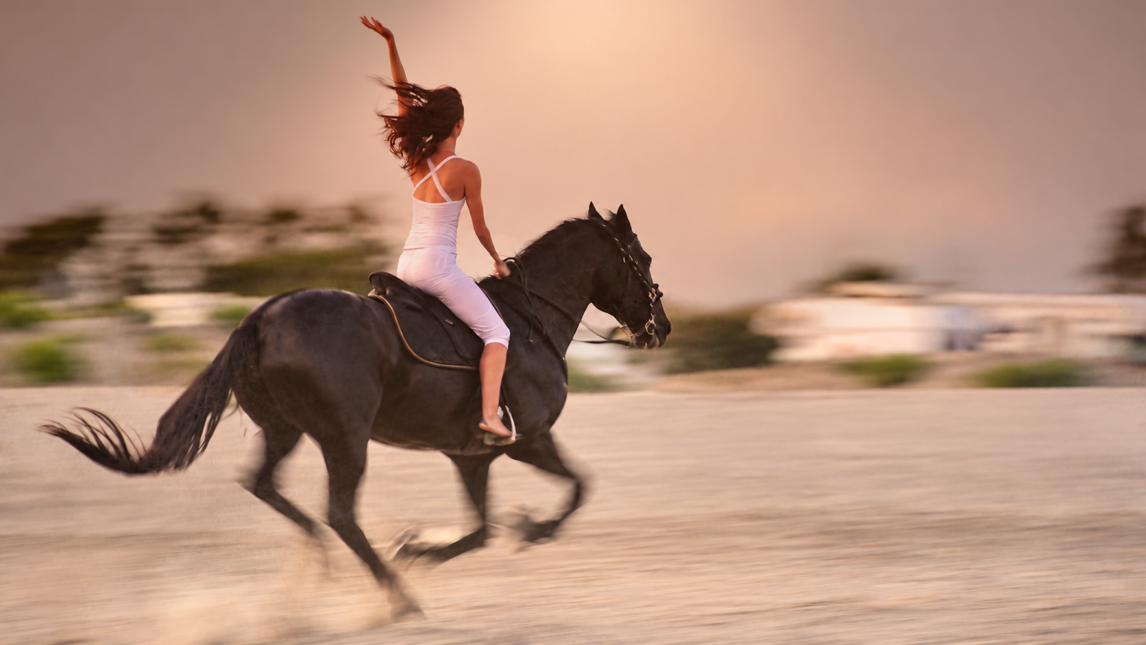 Woman riding a horse on the beach